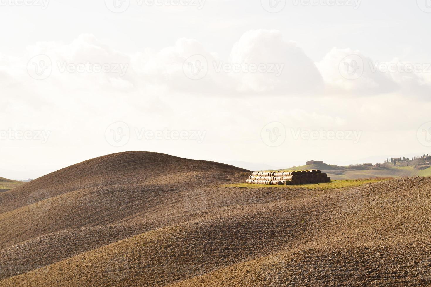 hooibalen en bewerkte landbouwgrond overdag in italië foto