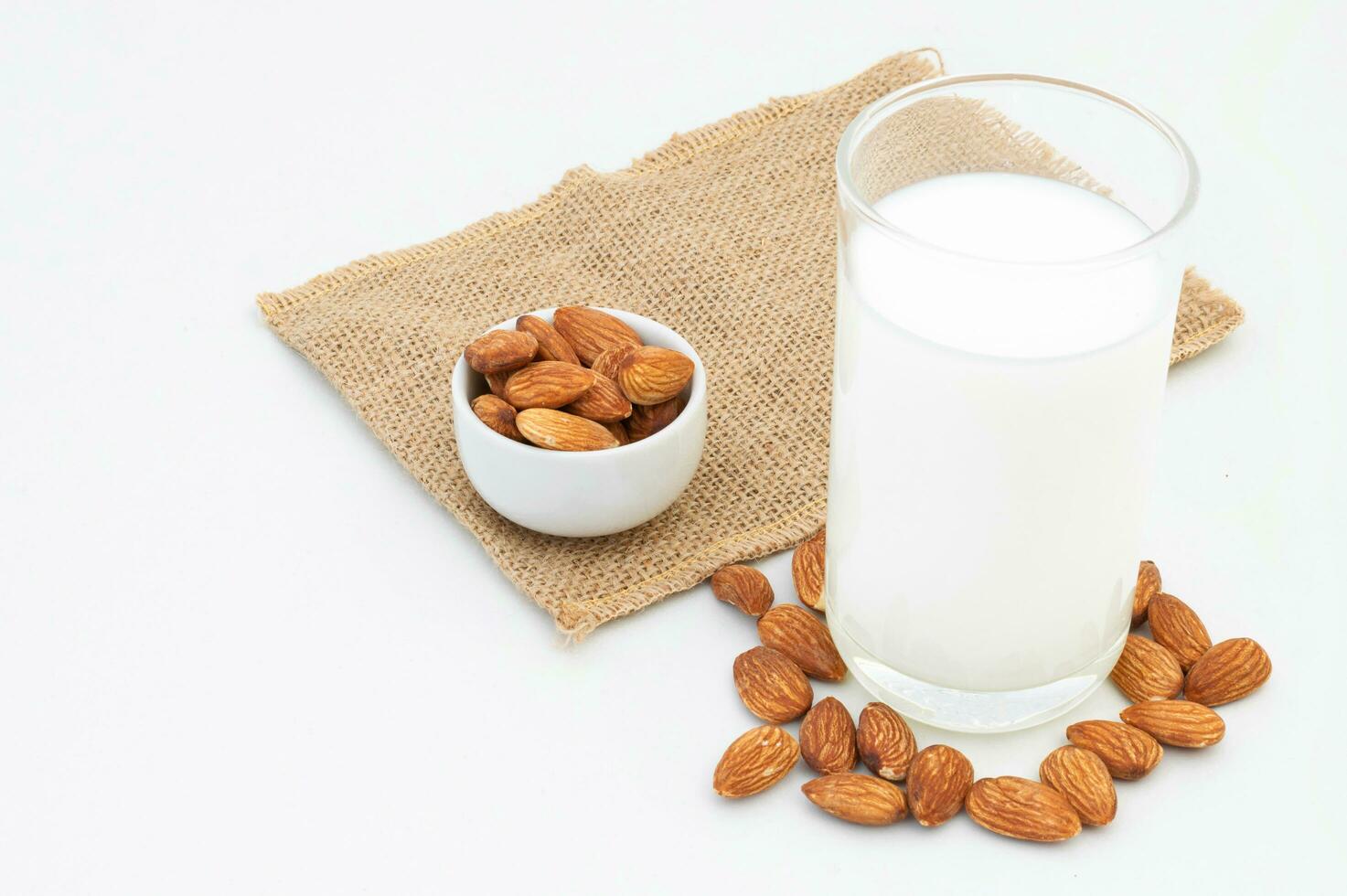 melk amandelen in een glas Aan een wit achtergrond foto