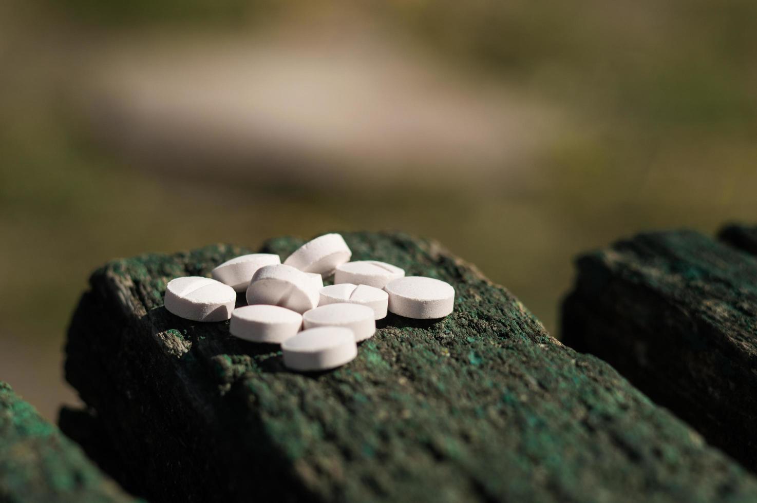 witte pillen liggen op een oud bankje foto