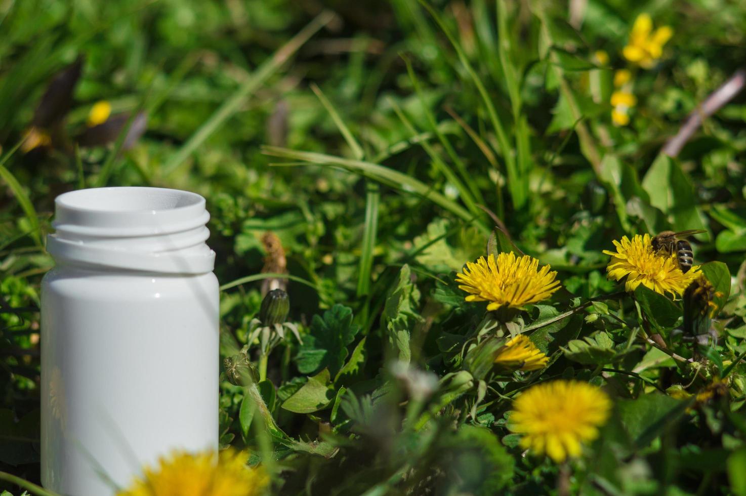 witte pillen in het gras met bloemen foto