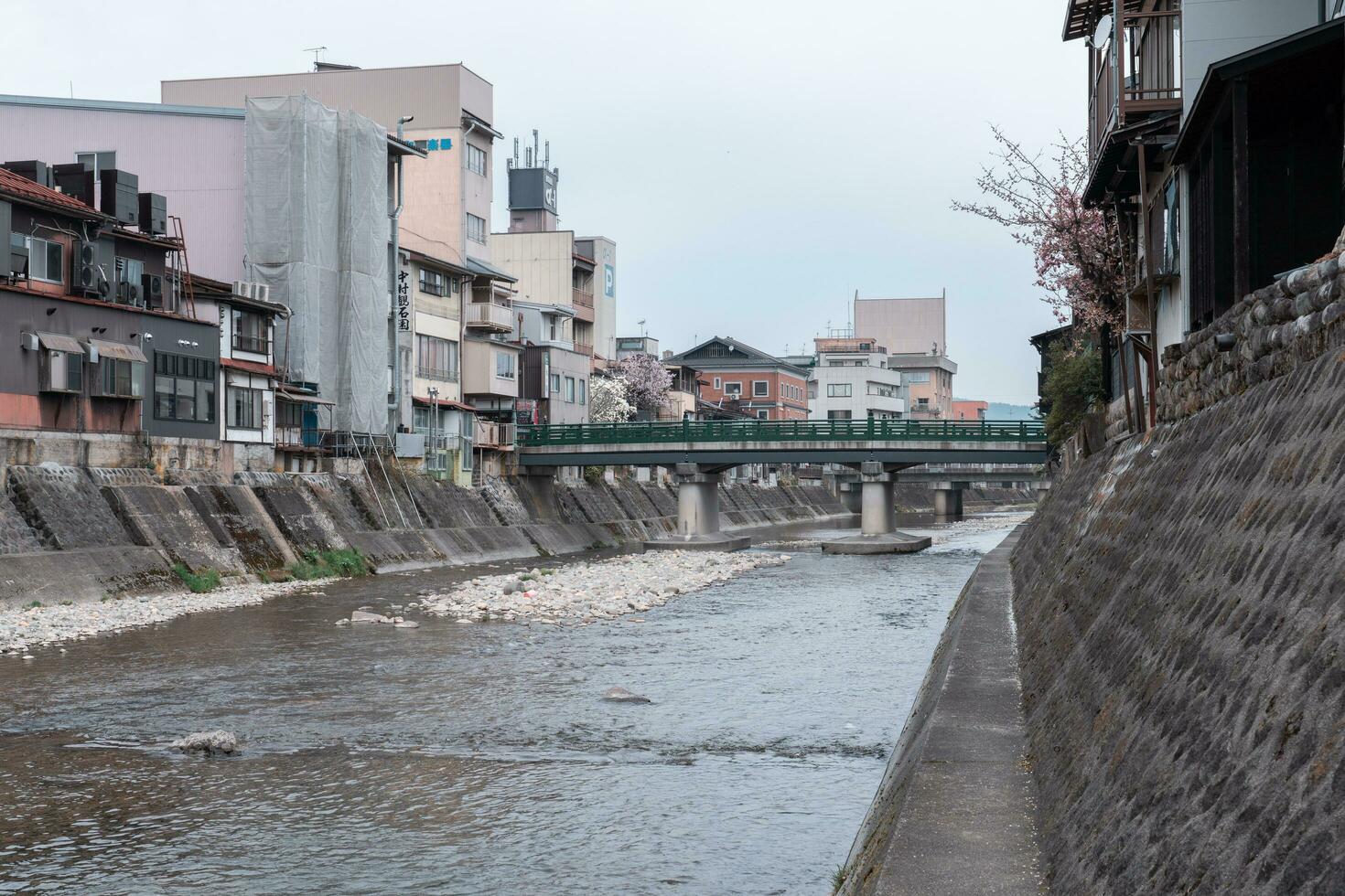 takayama, Japan - april 5, 2023 yanagibashi brug, traditioneel Japans groen brug met sakura kers bloesem in april foto