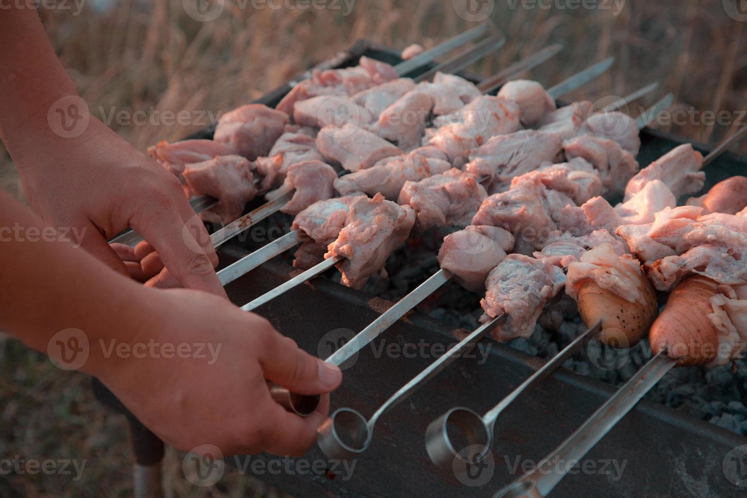 man frituren shish kebab op de grill foto