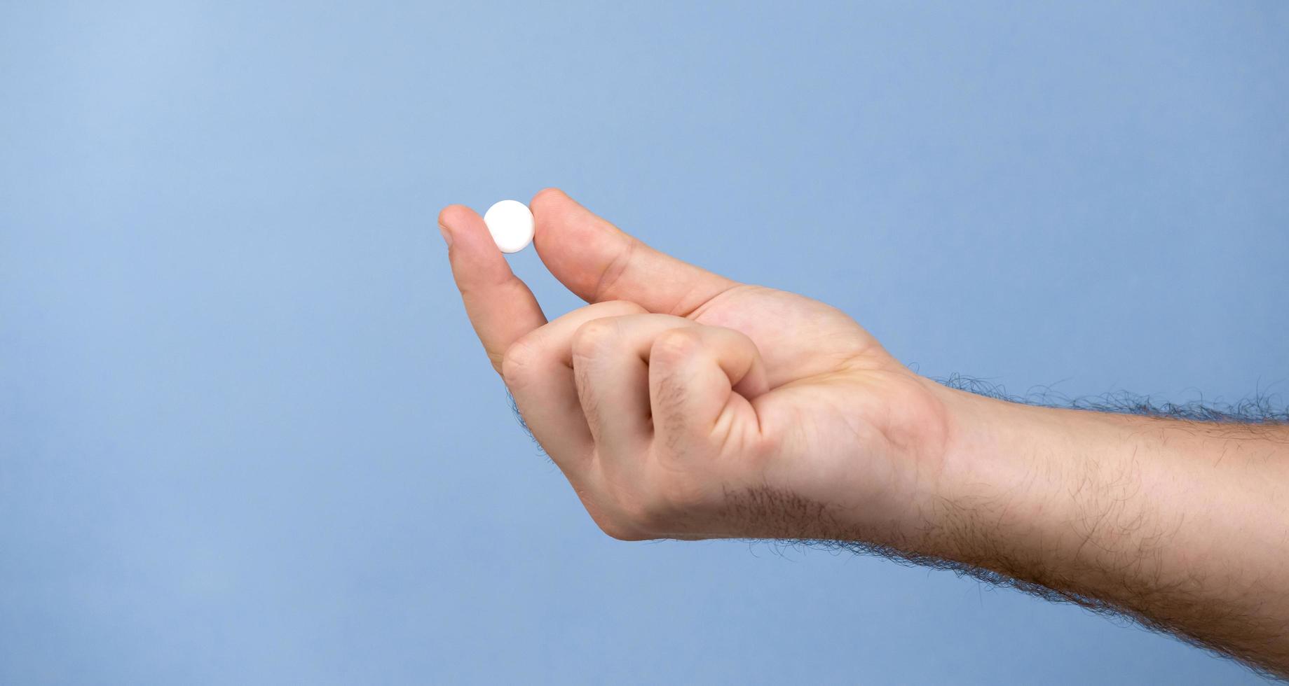 een pil in een mannenhand foto