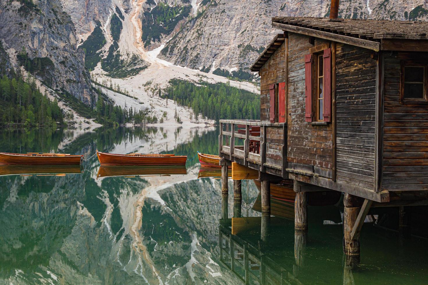 close-up van iconisch botenhuis en boten met mount seekofel weerspiegeld in het heldere kalme water van pragser wildsee lago di braies in dolomieten unesco werelderfgoed foto