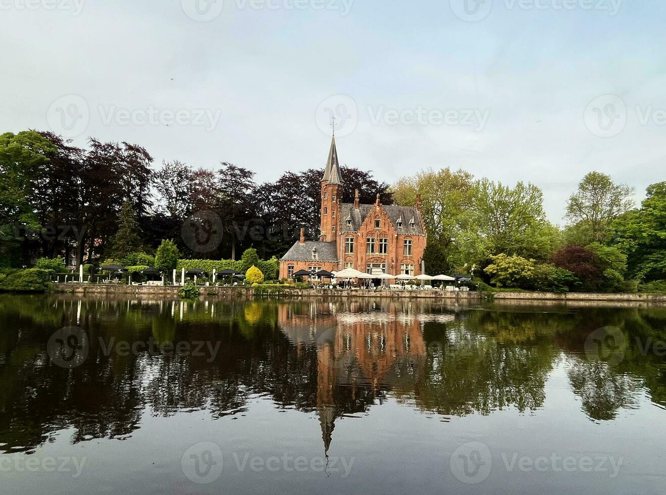 mijnwater oude middeleeuws gotisch rood steen kasteel Bij de meer van liefde in Brugge in openbaar park zone, belgië, helder zonnig dag, mooi natuurlijk landschap, gebouw reflectie in water foto