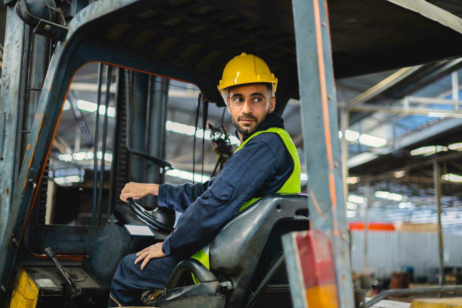 arbeider vervelend helm met het rijden heftruck achteruit in magazijn foto