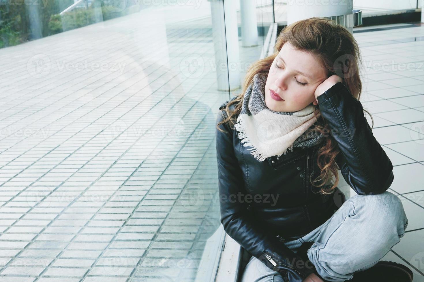 jonge mooie vrouw weerspiegeld in een groot raam foto