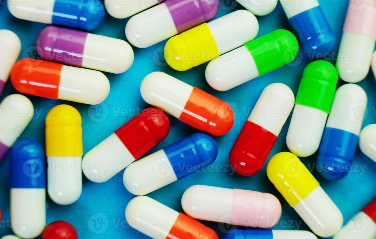 een gedetailleerde macro van pillen en capsules met blauwe achtergrond foto
