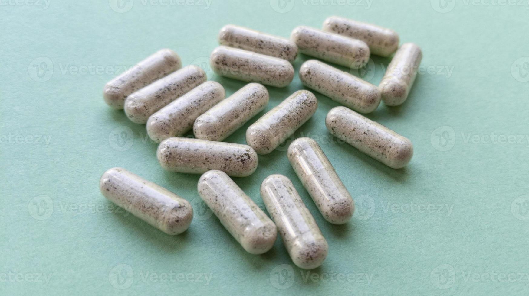 pil capsules met droge kelp op mint achtergrond eenvoudig plat leggen met pastel textuur medische concept stock foto