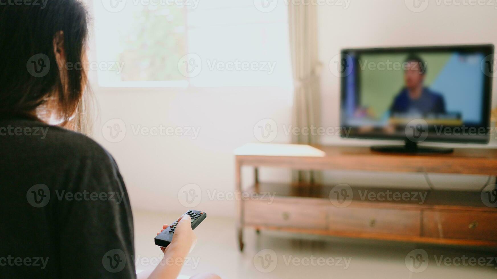 aan het kijken slim TV en gebruik makend van afgelegen controleur TV hand- Holding televisie audio afgelegen controle met de afgelegen controle televisie. foto