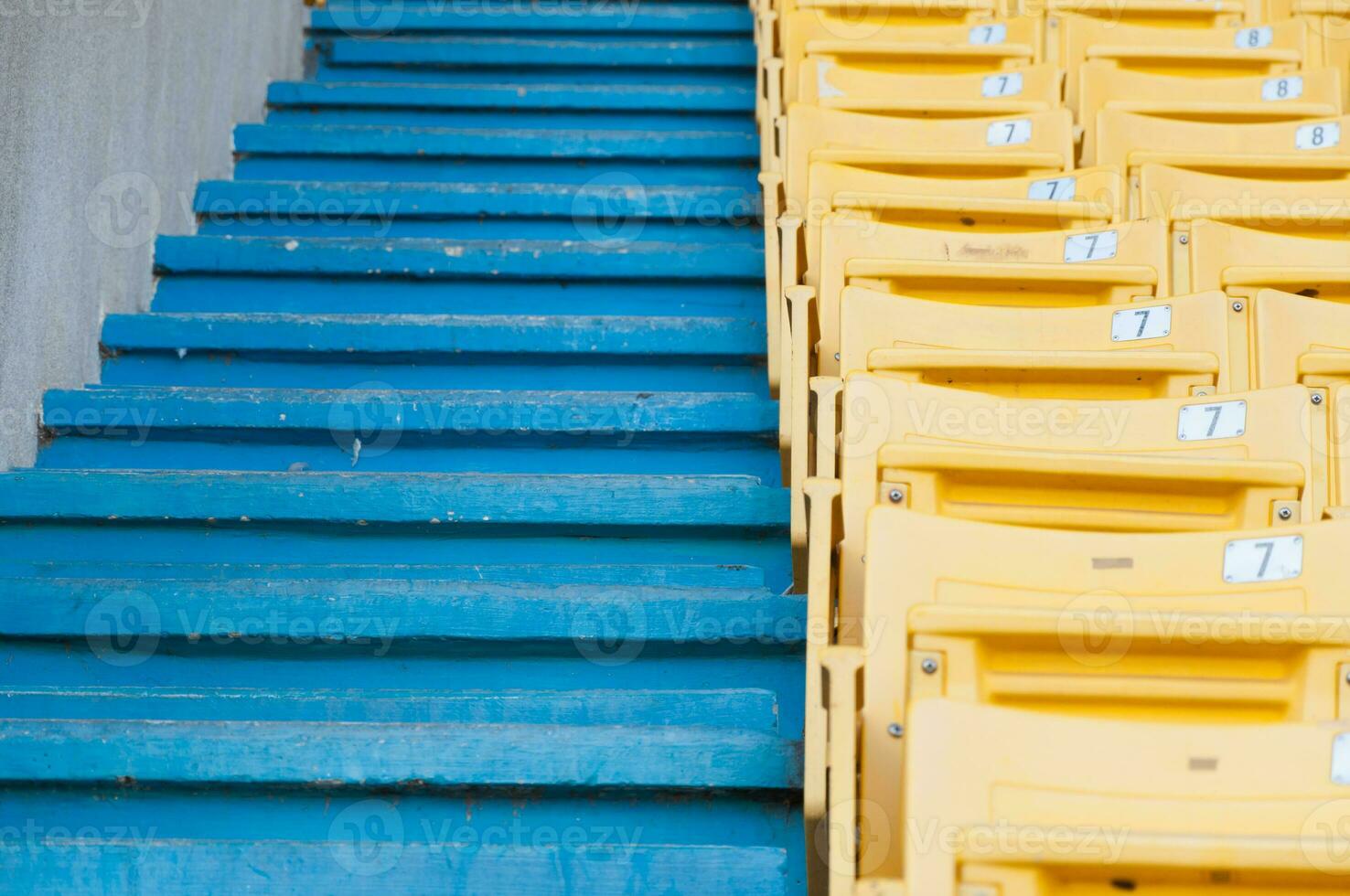 leeg geel stoelen Bij stadion, rijen loopbrug van stoel Aan een voetbal stadion foto