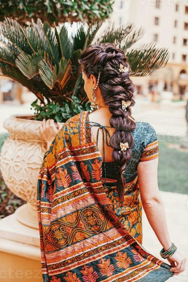 terug kant portret van Indisch vrouw vervelend Saree en mooi gevlochten kapsel Aan haar lang haar- foto