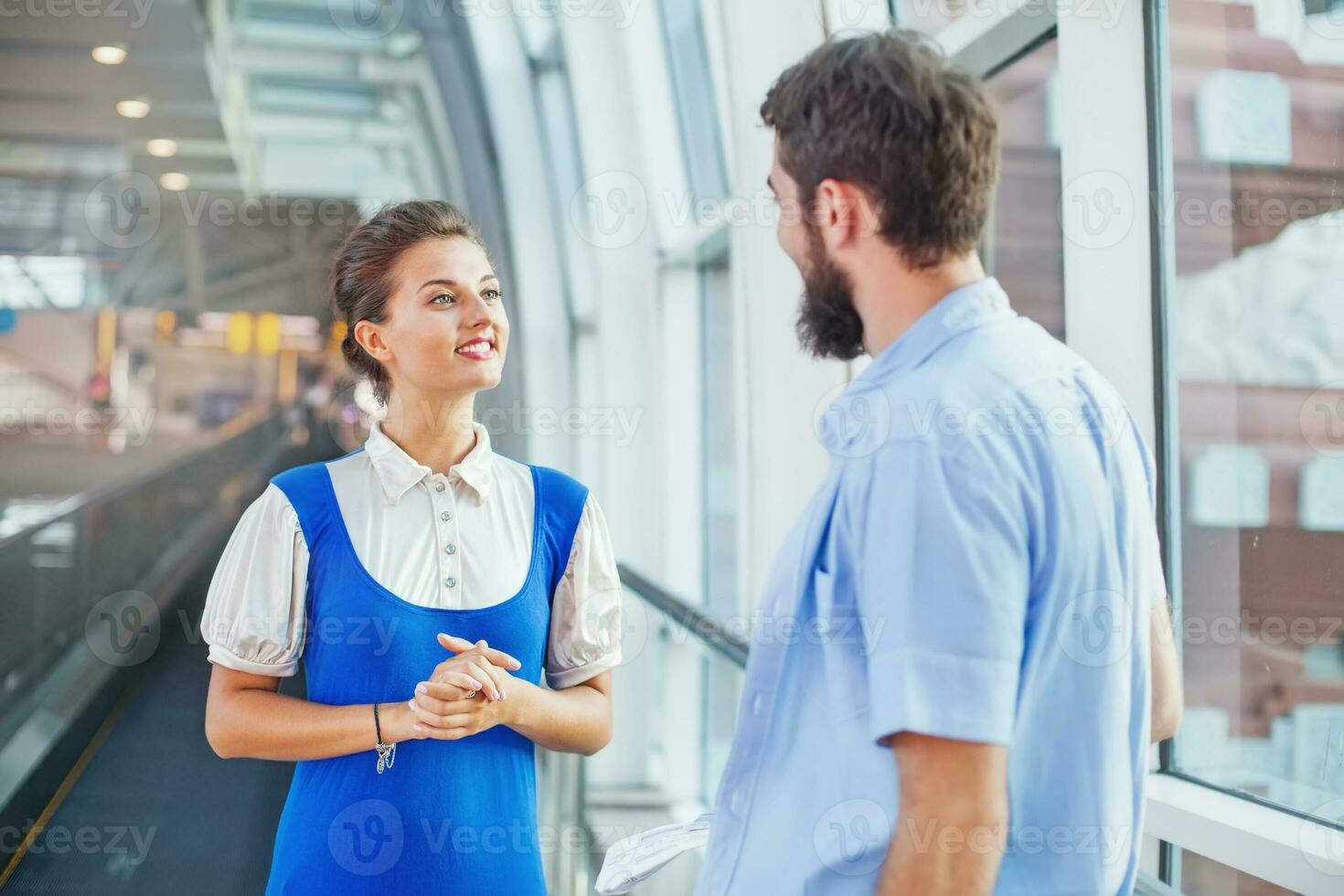 mooie jonge stewardess in de luchthaven uit te leggen de weg foto