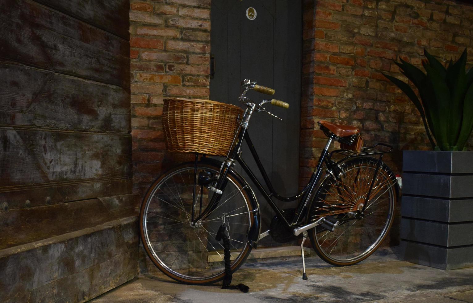 zwarte stadsfiets naast bruine bakstenen muur foto