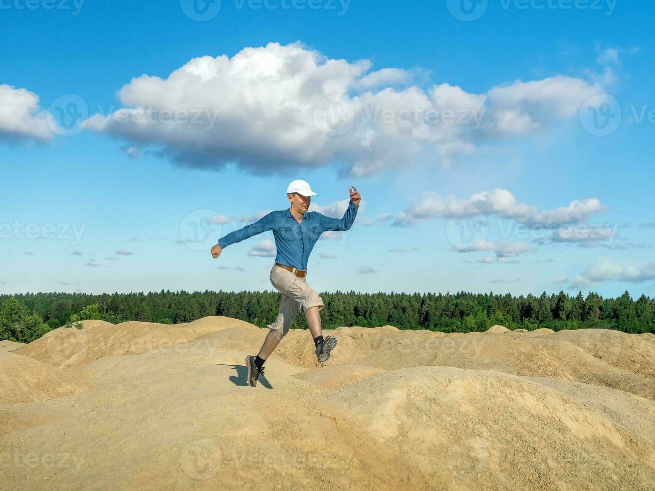 een vrolijk Mens springt Aan de heuvels foto