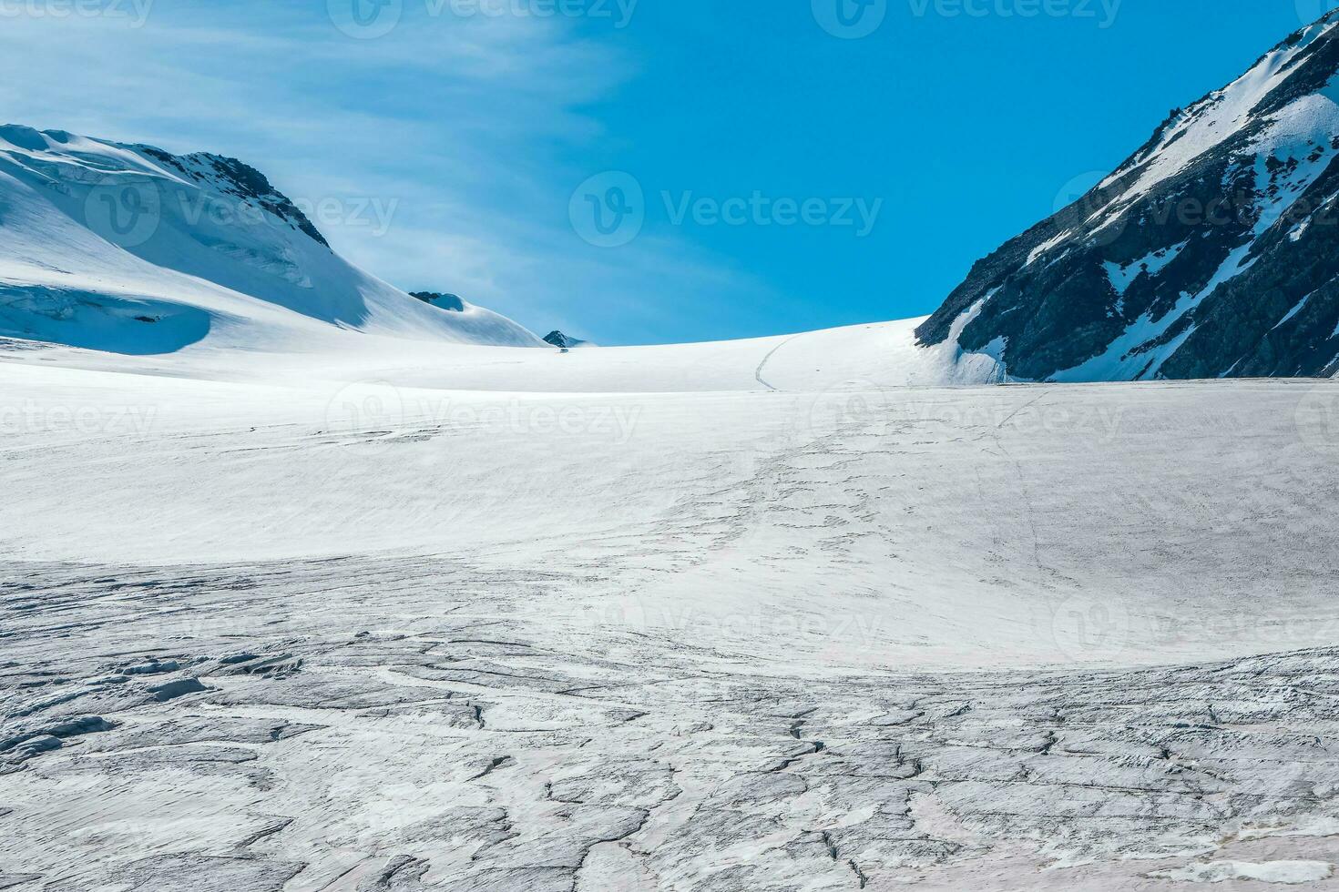 visie van besneeuwd helling Aan de manier naar de voorbij gaan aan in de bergen. sfeervol berg landschap met gletsjer Aan rotsachtig heuvel. geweldig landschap met steenachtig voorbij gaan aan met sneeuw in zonlicht. foto