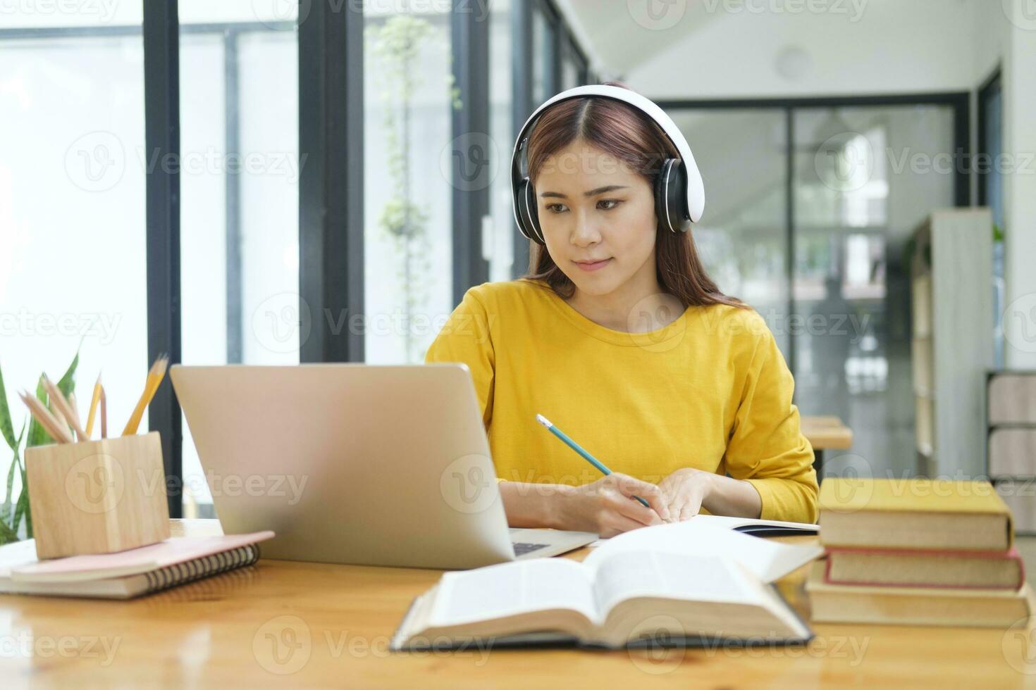 vrouw aan het leren online gebruik makend van laptop en schrijven notities. foto