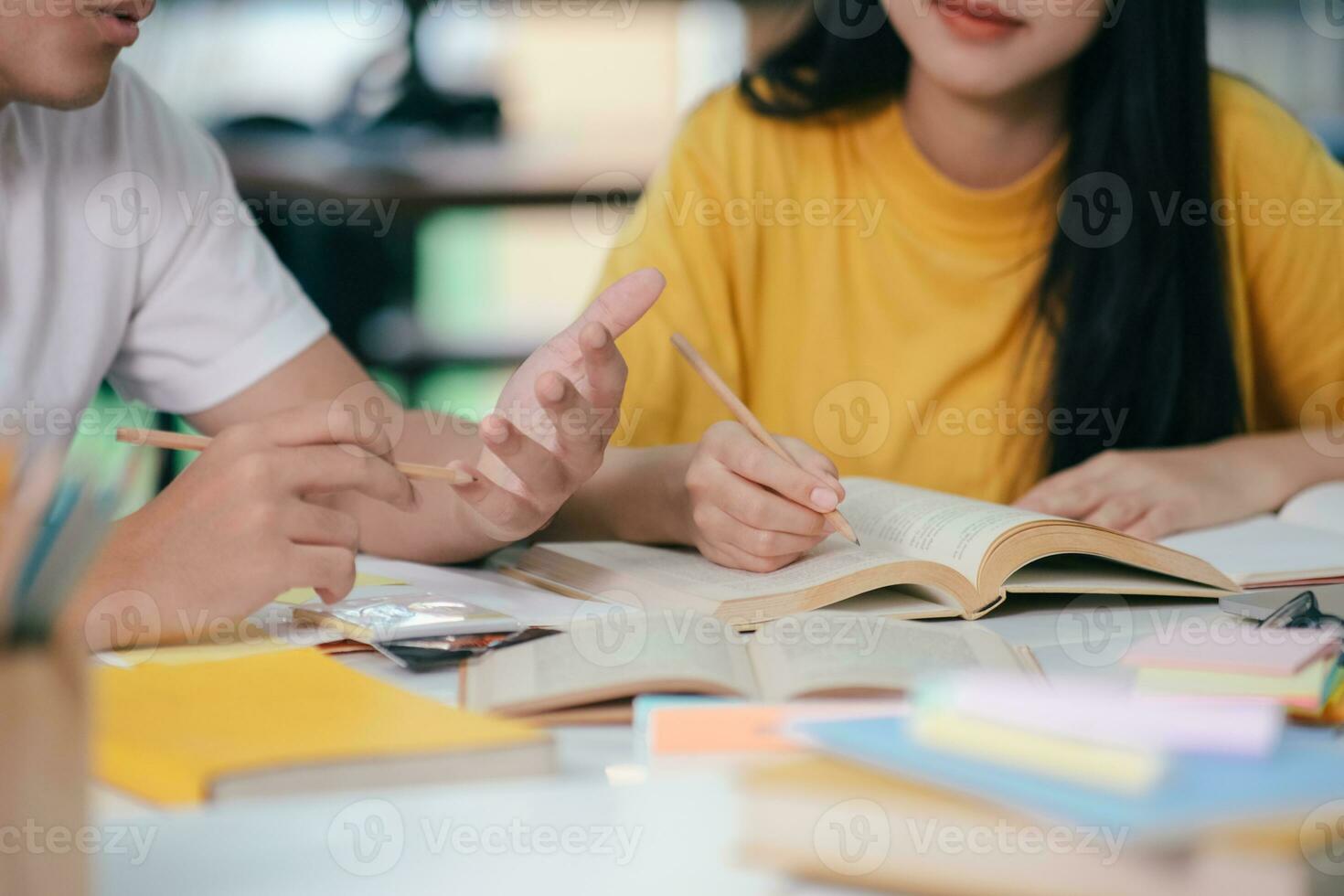 een Aziatisch studenten zijn lezing boeken en studie, bijles samen. foto