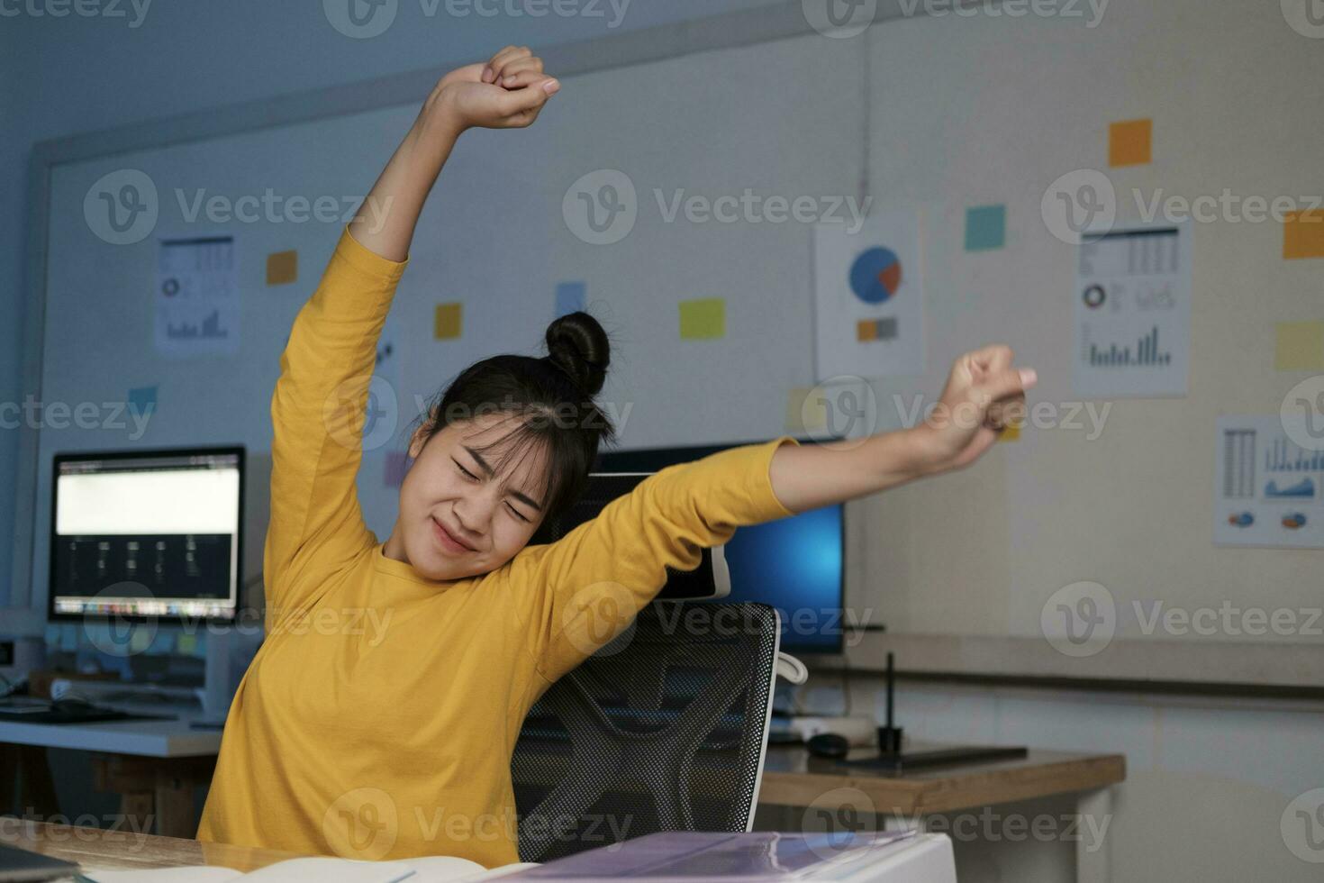 vrouw draaien de lichaam naar kom tot rust terwijl zittend net zo ze zit Bij haar bureau na werken allemaal dag. foto