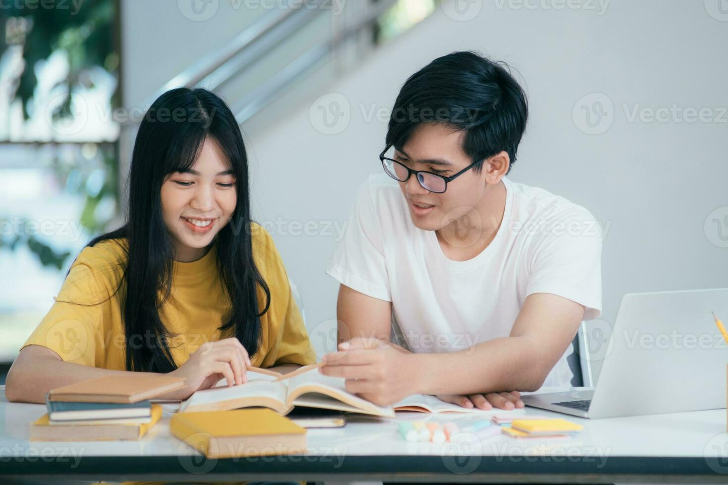 een Aziatisch studenten zijn lezing boeken en studie, bijles samen. foto