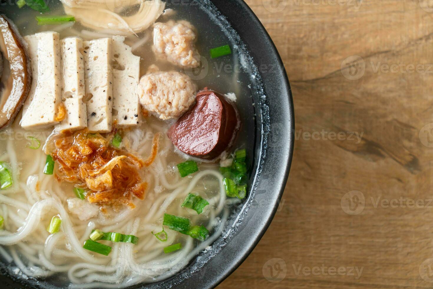 Vietnamese rijstnoedelsoep met Vietnamese worst geserveerd met groenten en krokante ui foto