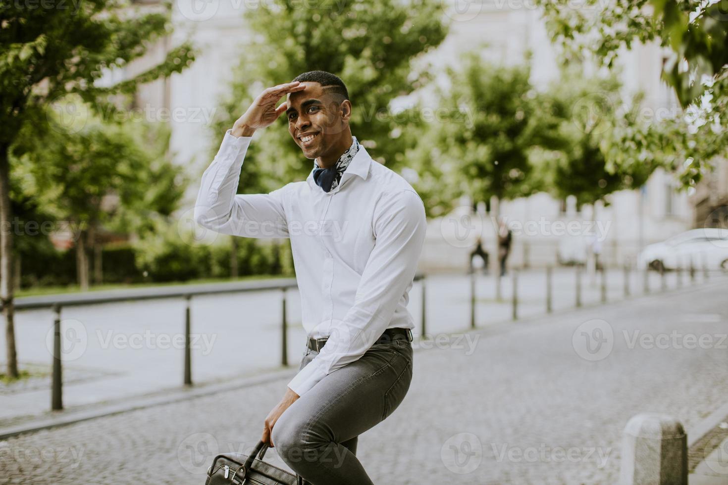 jonge Afro-Amerikaanse zakenman waitng een taxi in een straat foto