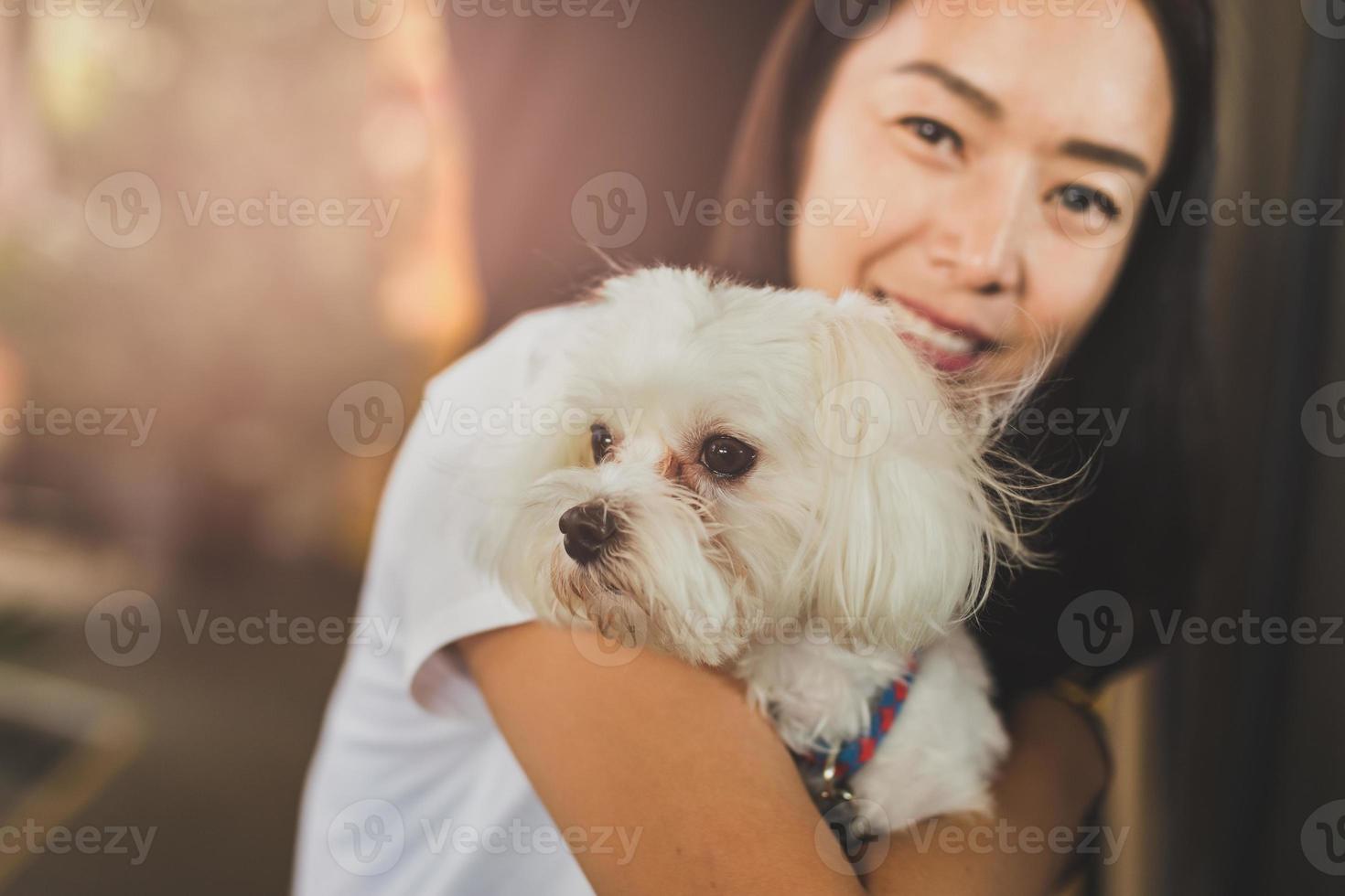 vrouw is huisdiereneigenaar die kleine hond houdt foto