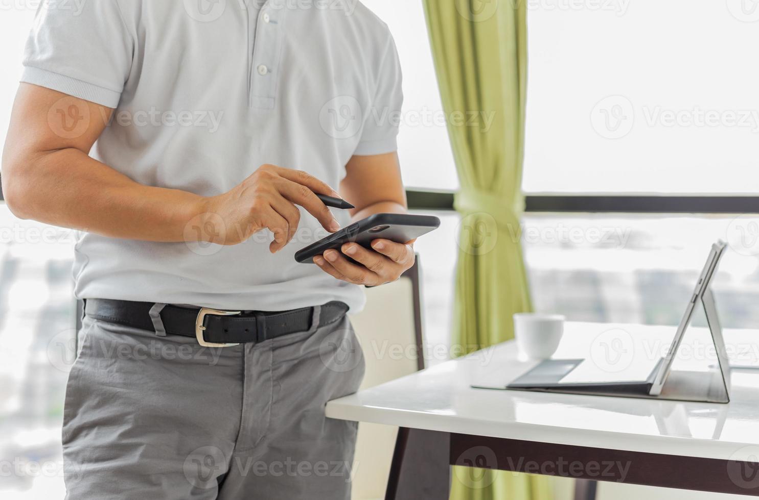 zakenman bezig met mobiele telefoon met laptop op tafel foto