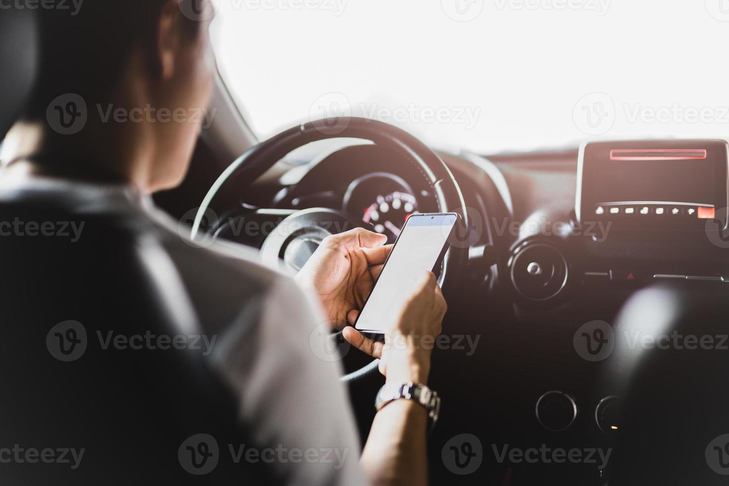 man met behulp van slimme telefoon tijdens het rijden foto