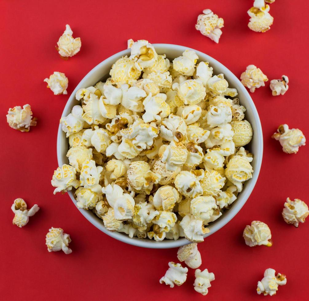 close-up van paddestoel popcorn in een witte kom met rode achtergrond foto