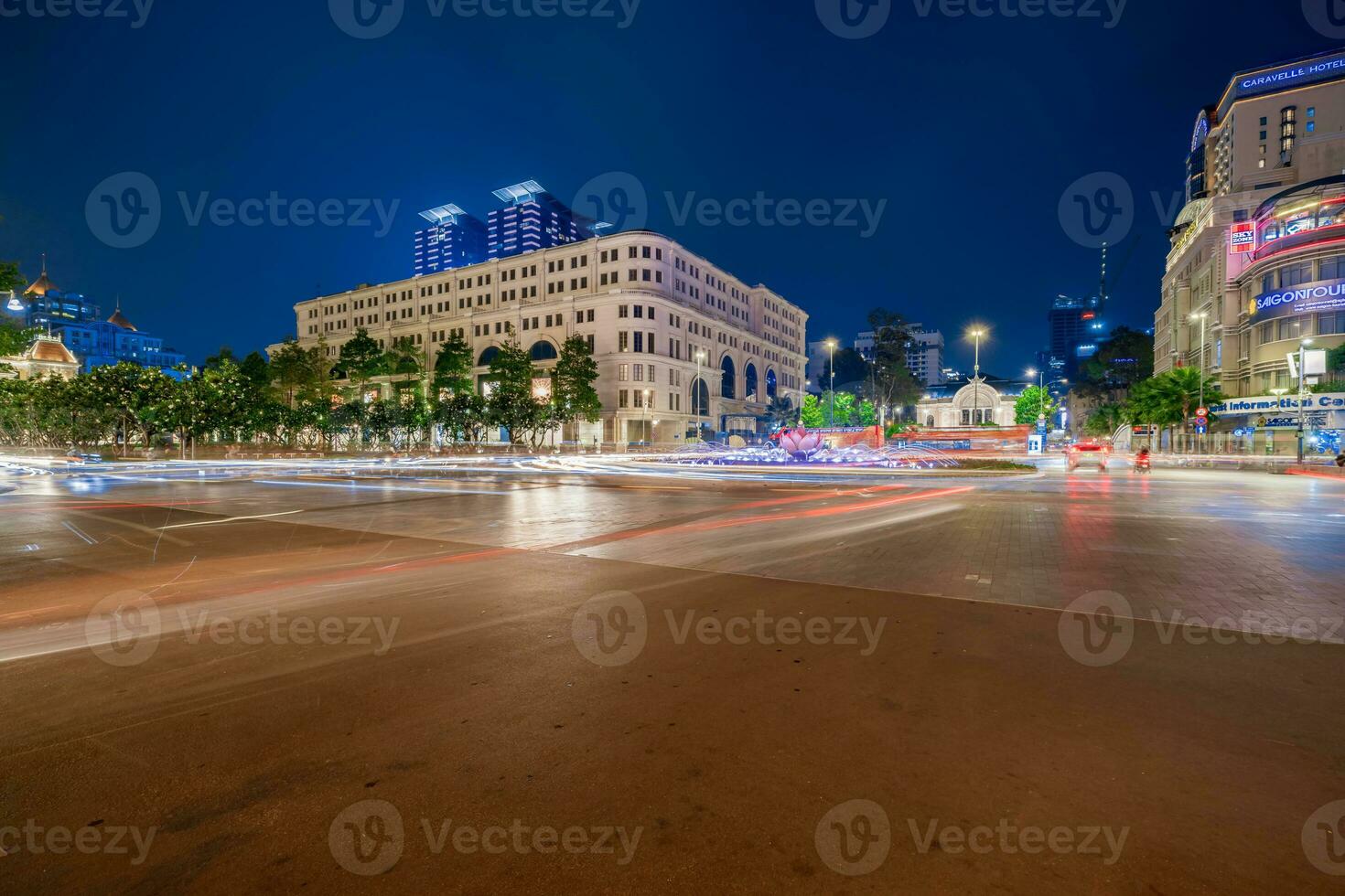 ho chi min, viet naam - 10 april 2023 Saigon stad hal, vincom centrum torens, kleurrijk straat verkeer en tropisch planten tegen de verbazingwekkend nacht. Saigon downtown met haar beroemd oriëntatiepunten. foto