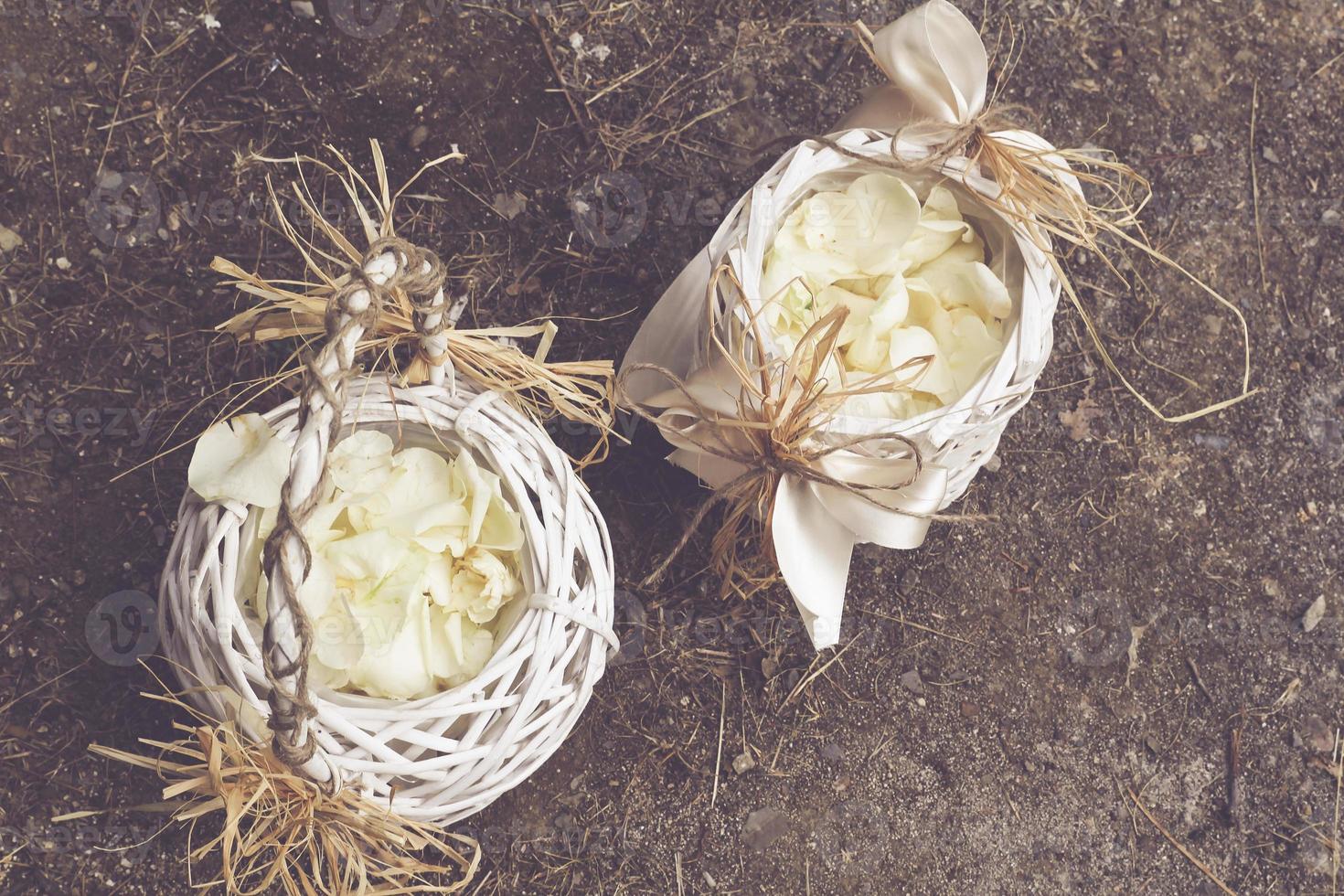 houten boeket mandje met witte rozenblaadjes foto