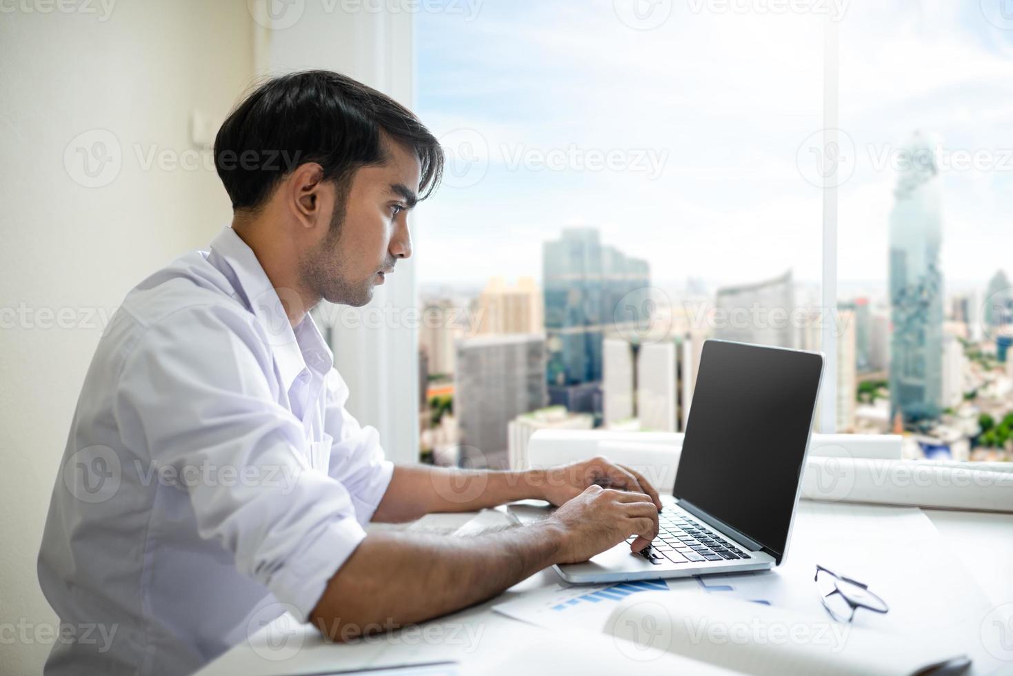 zakenman aan het werk met laptop en documenten foto