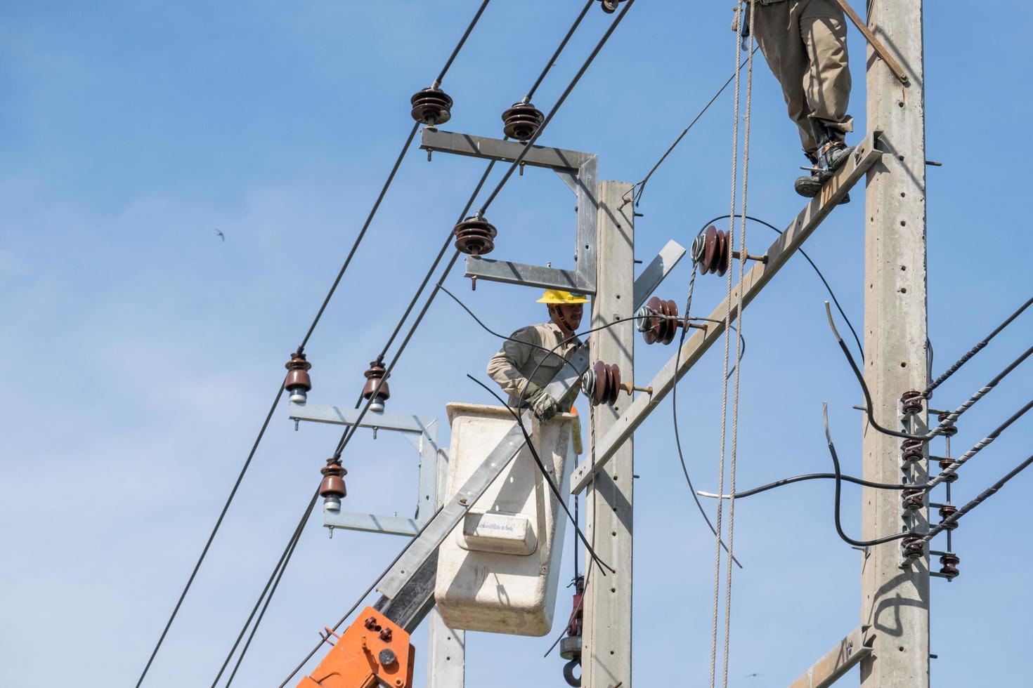 bangkok, thailand 2015 - elektriciens werken aan het repareren van hoogspanningsleidingen foto