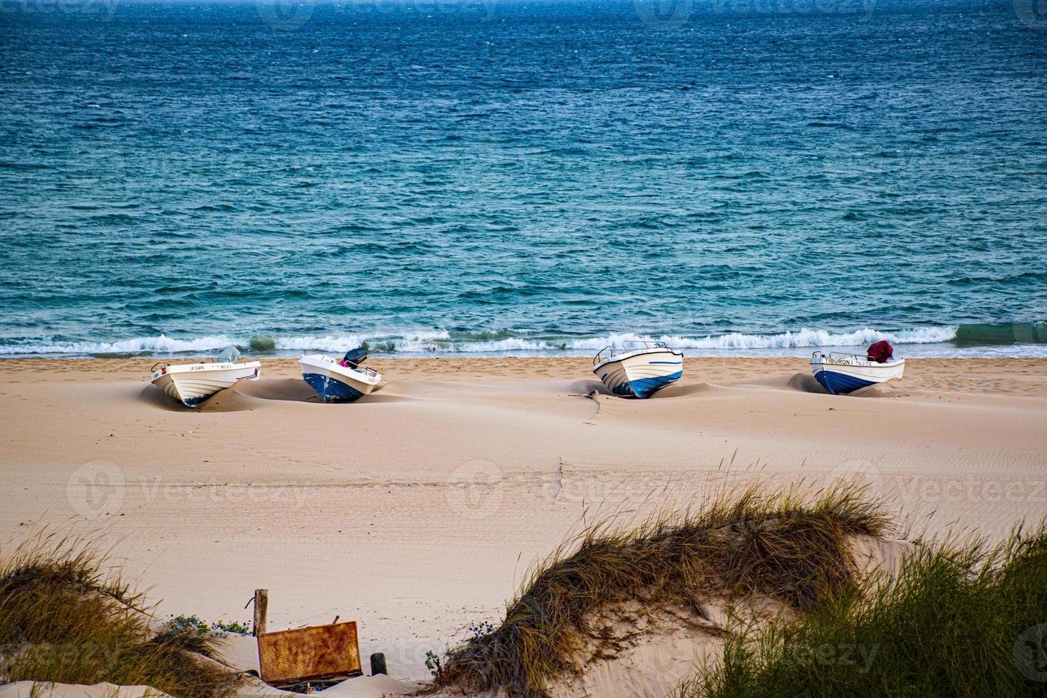 vier boten in het zand en de blauwe zee foto