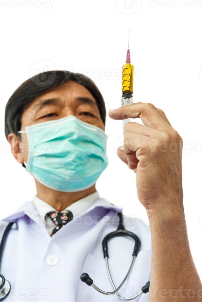 Aziatische arts houdt spuit op witte achtergrond en lege ruimte aan de bovenzijde foto