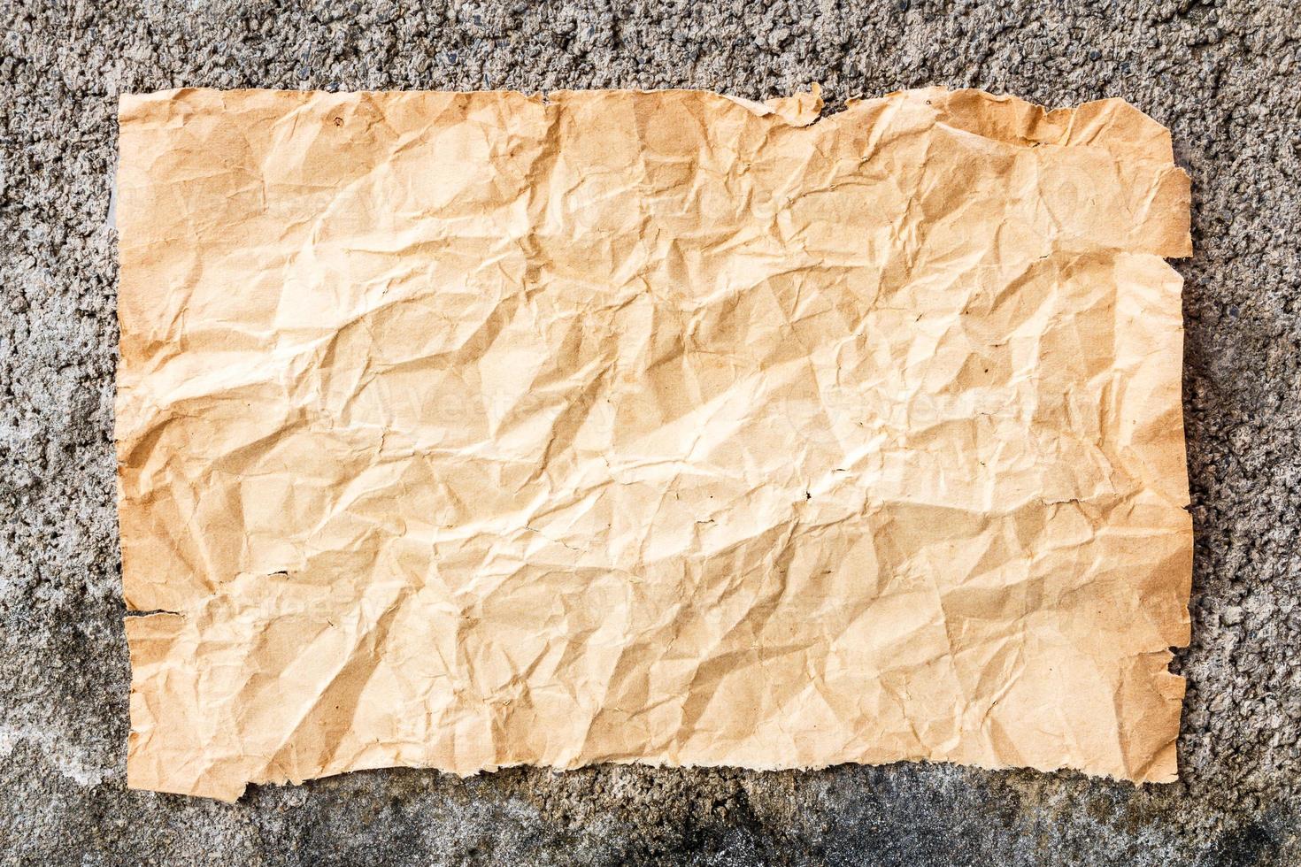 het oude verfrommelde papier op de betonnen muur foto