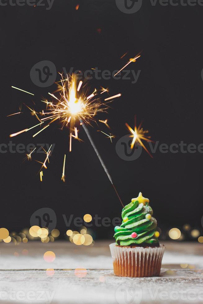 vanille cupcake met kerst bokeh en sterretje op donkere achtergrond vakantie achtergrond met kopie ruimte foto