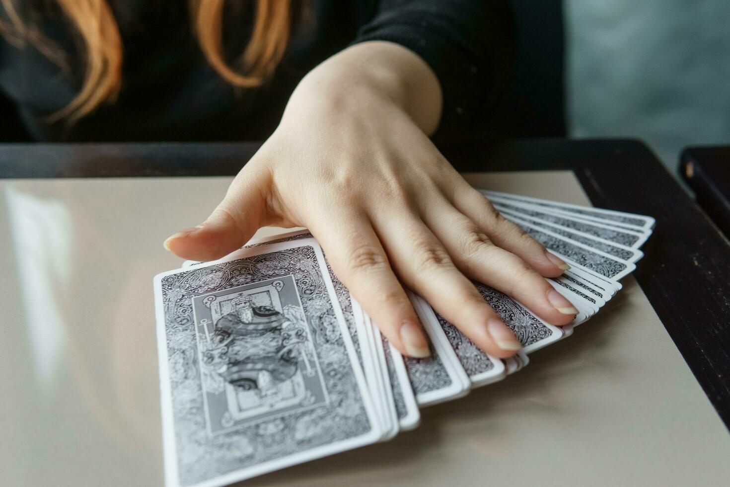 tver, Rusland - februari 11, 2023. tarot kaarten, tarot kaart waarzeggerij, esoterisch achtergrond. een vrouw maakt een lay-out Aan de kaarten Bij de tafel. waarzeggerij, voorspellingen Aan tarot kaarten. foto