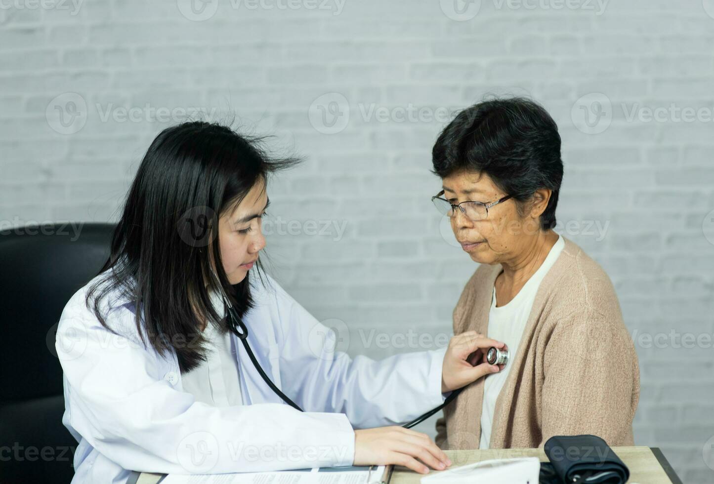 vrouw dokter meten hart tarief controleren voor ouderen vrouw geduldig Aan de dokter kantoor bureau. ouderen vrouw geduldig lijden van hypertensie controle voor ziekte in ziekenhuis. Gezondheid controleren omhoog. foto