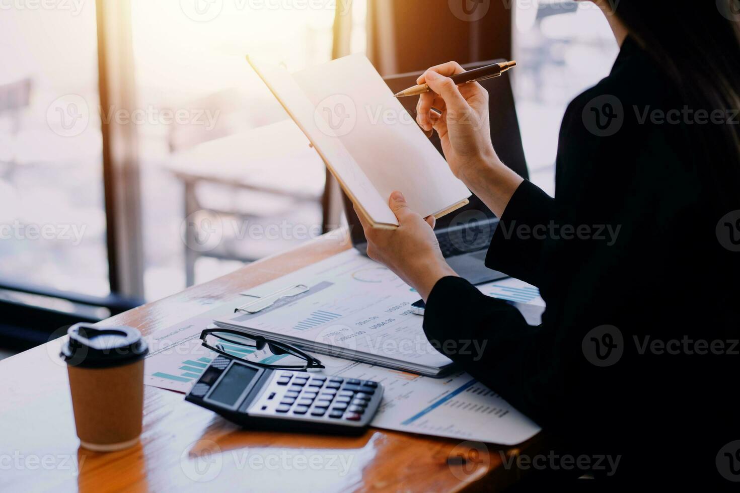 Aziatisch bedrijf vrouw gebruik makend van rekenmachine en laptop voor aan het doen wiskunde financiën Aan een kantoor bureau, belasting, rapport, boekhouding, statistieken, en analytisch Onderzoek concept foto