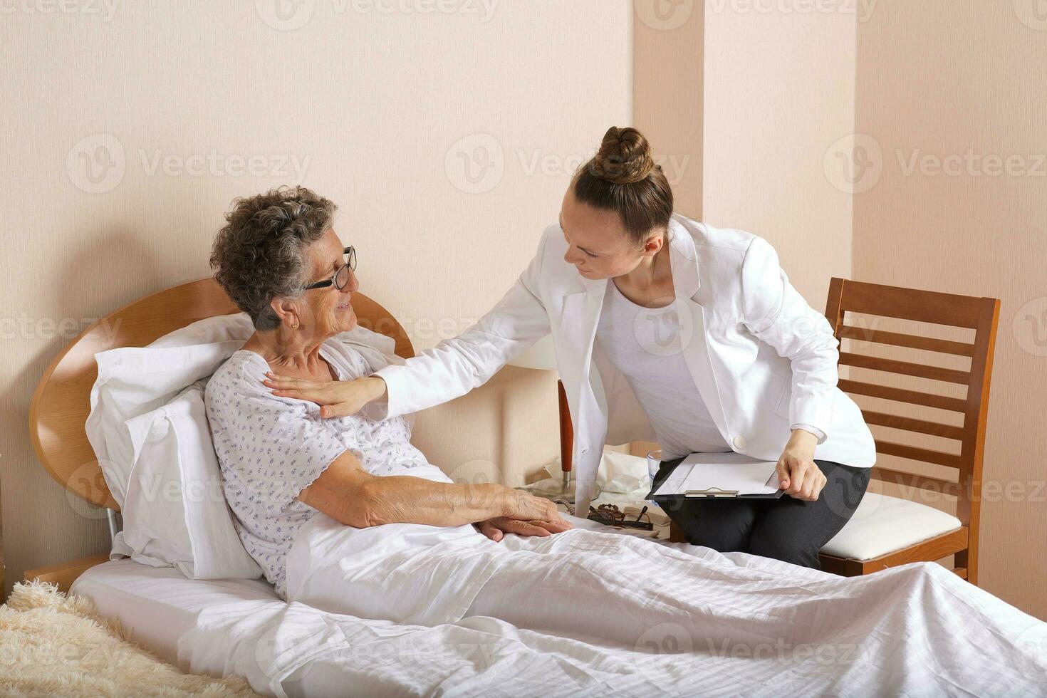 bezoek van senior sociaal werk assistent naar een oud vrouw foto