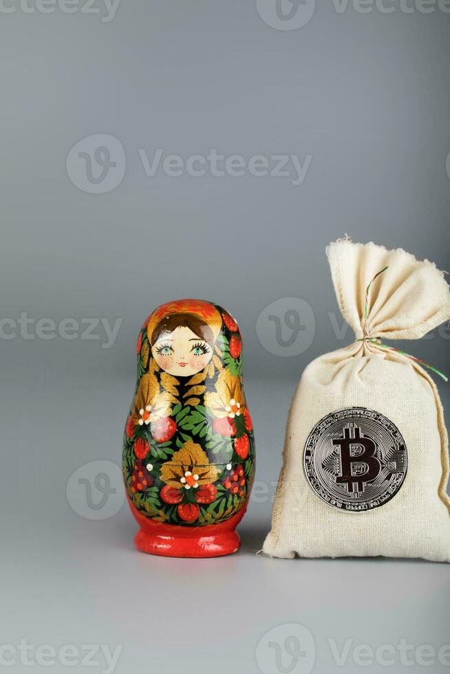 Russisch houten pop -matroesjka en zak van bitcoins. foto