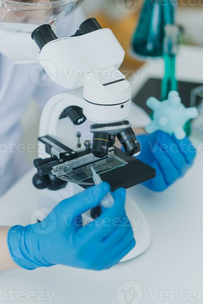 biochemisch onderzoeksteam dat werkt met microscoop voor de ontwikkeling van coronavirusvaccins in laboratorium voor farmaceutisch onderzoek, selectieve focus foto