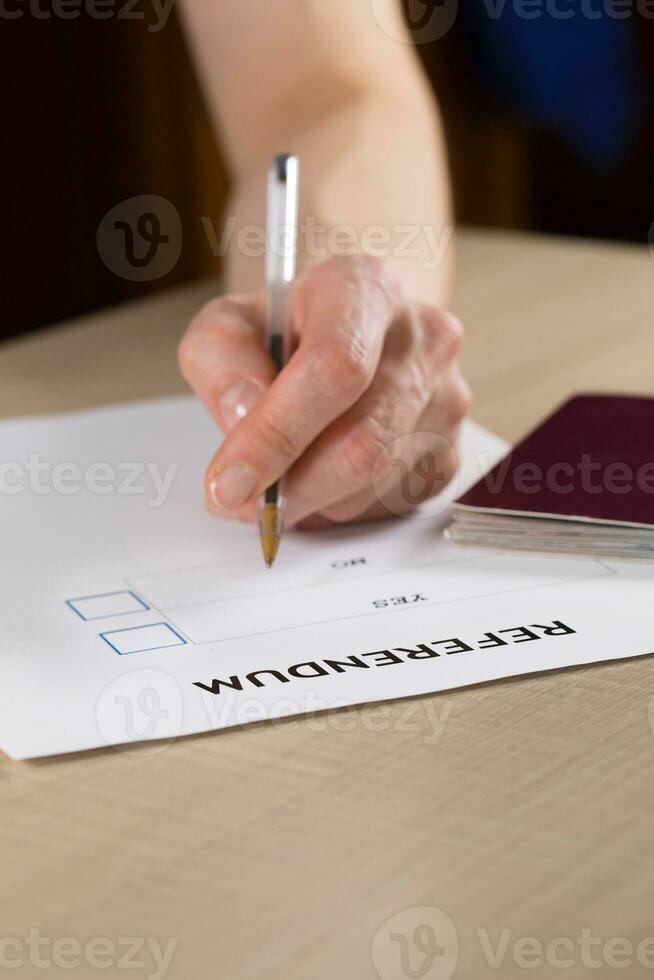 referendum stemming papier, zwart pen, en paspoort Aan de tafel. foto