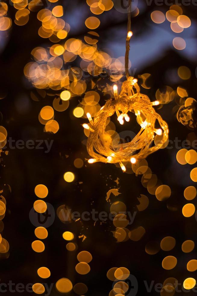 bokeh boom licht decoratie verwelkomend huis en de fantastische feest- en kerstnacht buitenbomen zijn versierd met gele lichten foto