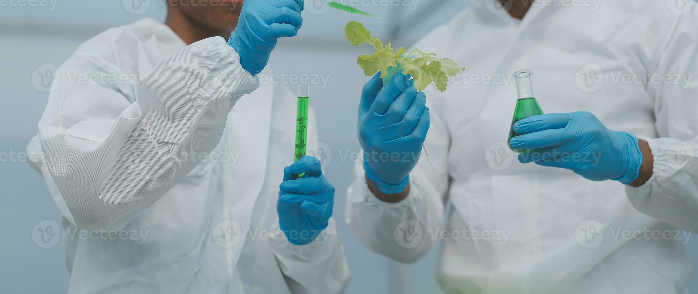 Mens en vrouw gebruik een test buis en een pipet terwijl werken in een serre. foto