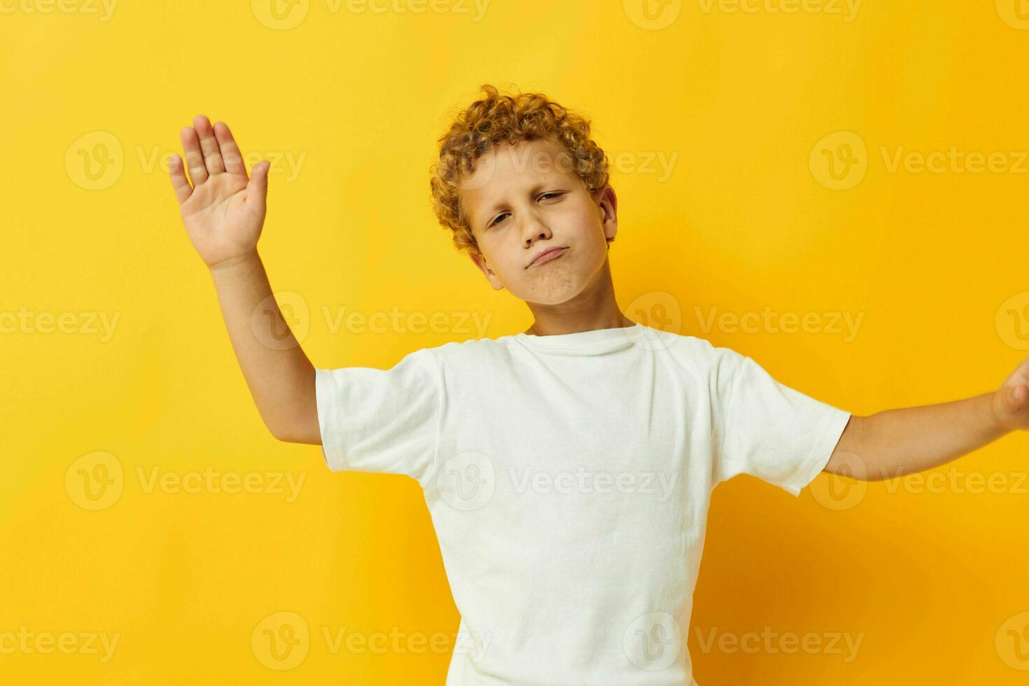 jongen met gekruld haar- kinderjaren poseren geel achtergrond foto