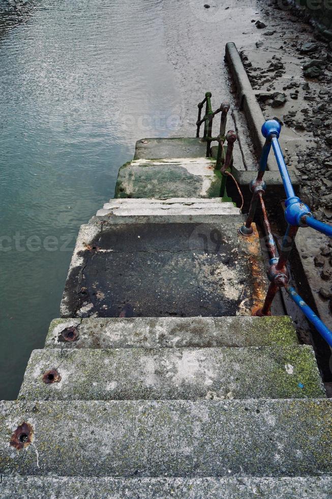 oude verlaten trappen in de zeehaven foto