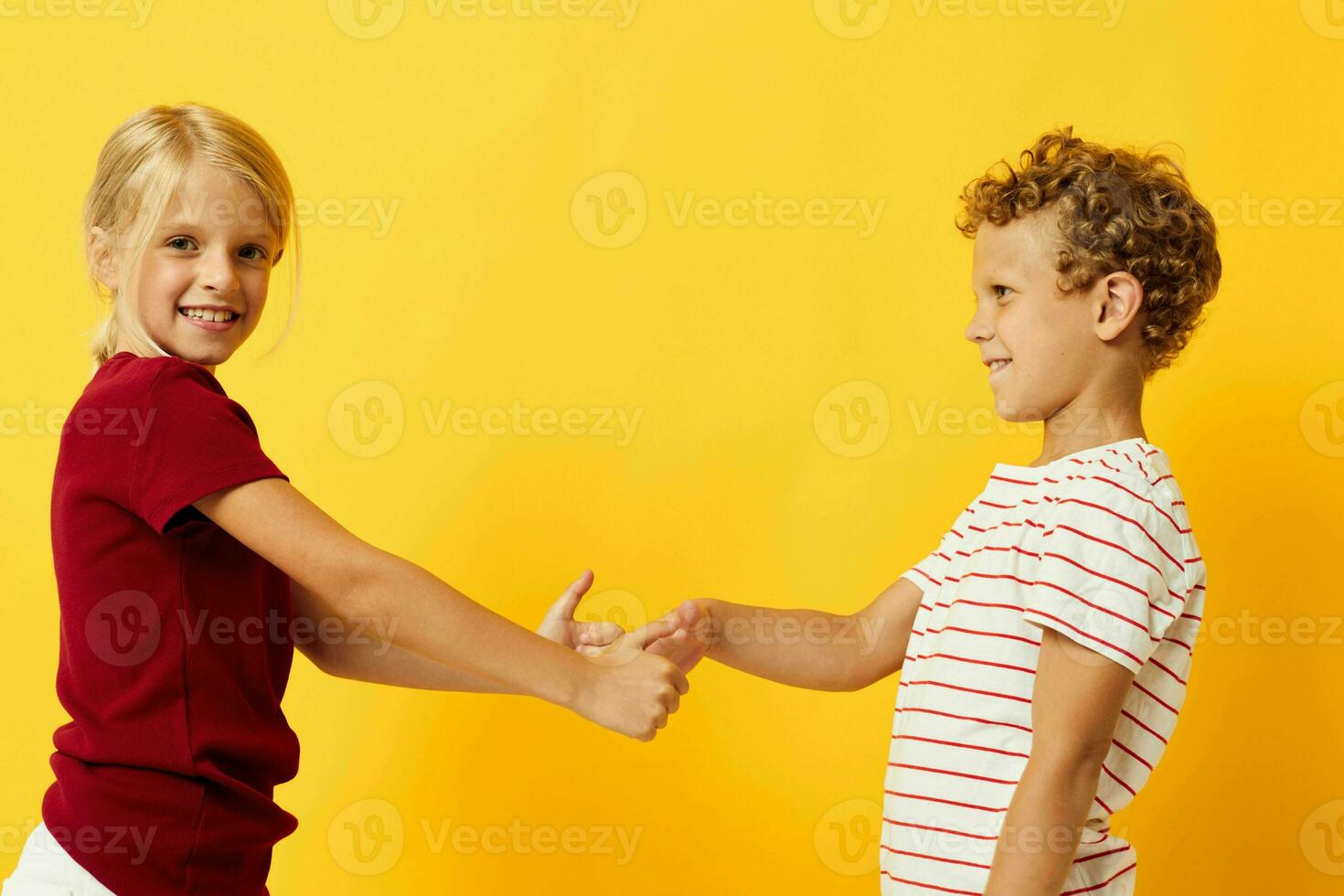 afbeelding van positief jongen en meisje staand kant door kant poseren kinderjaren emoties geel achtergrond foto